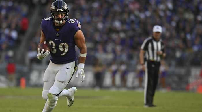 Baltimore Ravens tight end Mark Andrews runs with a ball in a game.